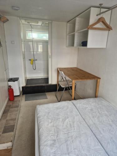 - une chambre avec un lit, une douche et une table dans l'établissement HouseBoat, à Amsterdam