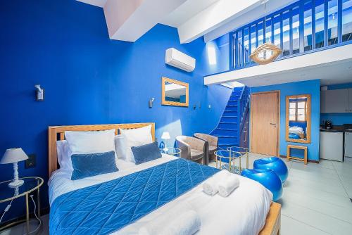 - une chambre bleue avec un lit et un mur bleu dans l'établissement Suites Coronell d'En Vila, à Perpignan