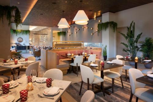 a restaurant with tables and chairs and a bar at Caesars Republic Scottsdale, a Hilton Hotel in Scottsdale