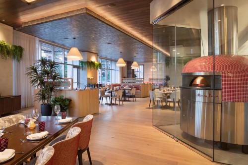 a dining room with tables and chairs and a restaurant at Caesars Republic Scottsdale, a Hilton Hotel in Scottsdale