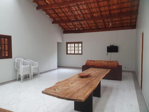 a living room with a wooden table and a couch at Chácara Rosa Maria in São Paulo
