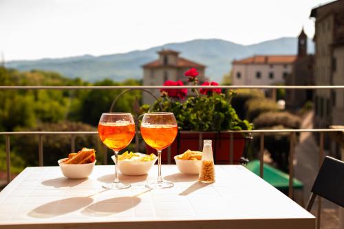 twee glazen wijn zittend op een tafel met snacks bij B&B Al Bodregon in Bagnone