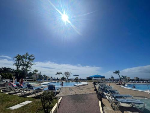 a pool with chaise lounge chairs and people swimming at Ankerplatz - casa Juseli - Ruhe und Erholung in Santa Úrsula