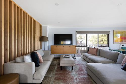 a living room with couches and a flat screen tv at Deluxe family home near beach with views sleeps 10-12 in Ocean Grove