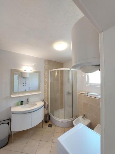 Un baño con ducha, lavabo e inodoro. en Charmy Apartments Petra with Pool, en Makarska