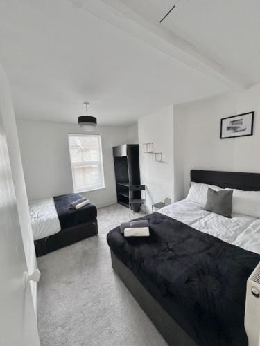 a bedroom with two beds and a couch in it at Gillingham 4 bed Guest House in Gillingham