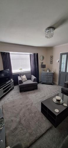 uma sala de estar com um sofá e uma mesa em Liverpool Air b and b em Sefton