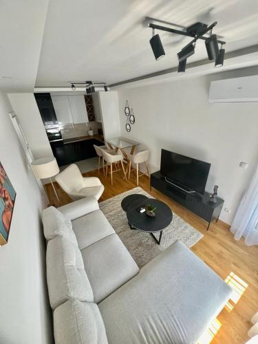 a living room with a white couch and a table at Apartman Star Lux in Bijeljina