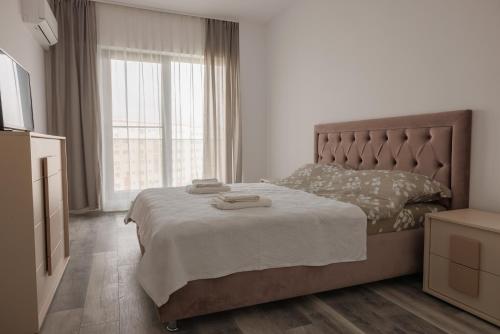 Un dormitorio con una cama y una ventana grande. en Rescossa Apartment, en Bucarest
