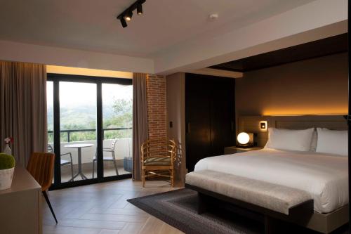 a bedroom with a bed and a view of a balcony at Camp David Ranch in Santiago de los Caballeros