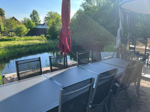 布倫瑞克的住宿－"Landhaus Thuner Heide" mit Kamin, Whirlpool & Feuerstelle，一张桌子和椅子,享有河景