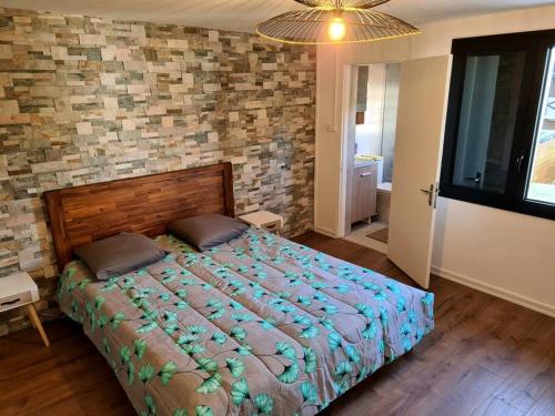 a bedroom with a bed and a brick wall at Maison Cosy in Saint-Denis