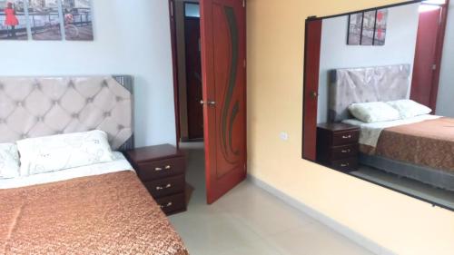 1 Schlafzimmer mit 2 Betten und einem großen Spiegel in der Unterkunft Hospedaje Roma in Huánuco