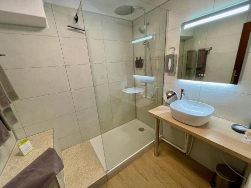 a bathroom with a glass shower and a sink at Chalet Le Panoramique in Mizoën