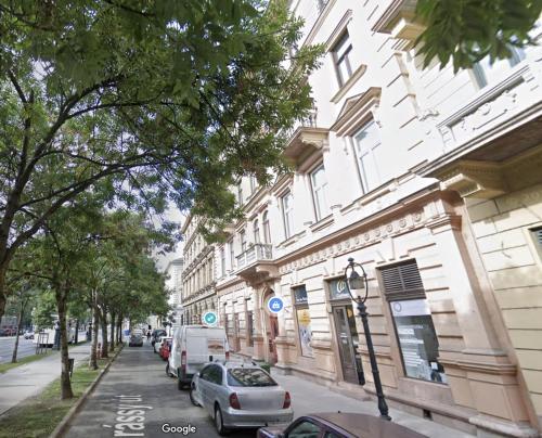 eine Straße mit Autos, die an der Seite eines Gebäudes geparkt sind in der Unterkunft Alice Apartment in Budapest