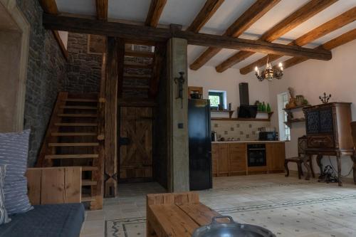 uma sala de estar com uma porta de madeira e uma cozinha em Vályog Vendégház em Balatonendréd