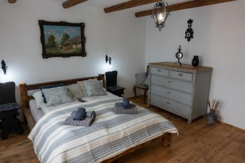 um quarto com uma cama e uma cómoda com chapéus em Vályog Vendégház em Balatonendréd