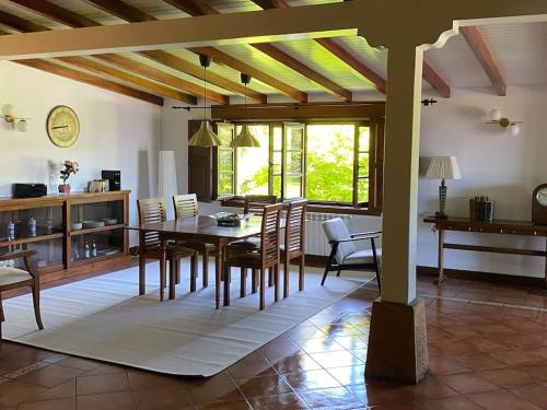 a kitchen and dining room with a table and chairs at Casa rural con piscina in Carasa