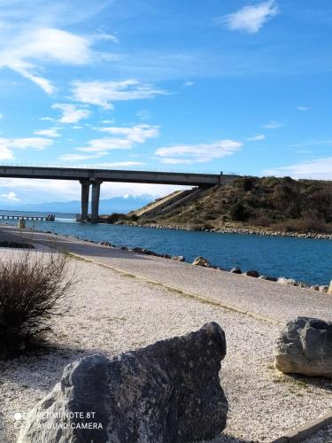 un pont sur un plan d'eau avec un rocher dans l'établissement Appartement cosy sur le port, à Leucate