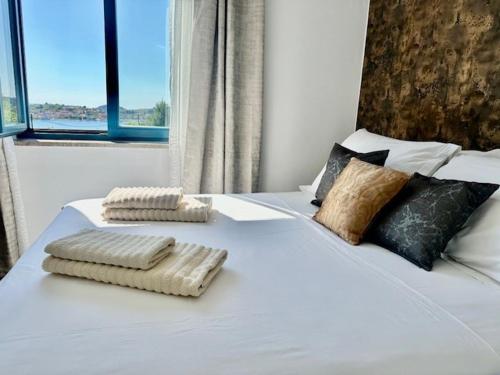 a white bed with two towels on top of it at Villa Dee in Lukoran