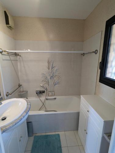 une salle de bain avec une baignoire blanche et un lavabo dans l'établissement Appartement avec vue mer exceptionnelle dans résidence de standing, au calme, avec piscine, à Mandelieu-la-Napoule