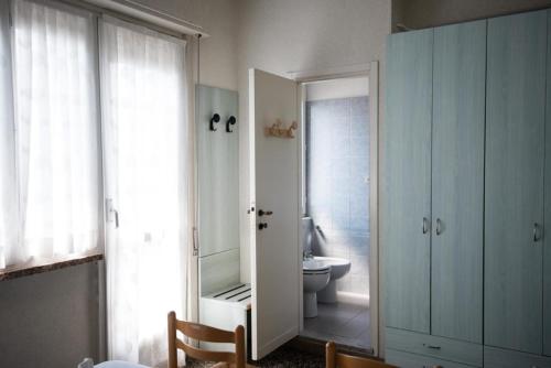 a bathroom with a toilet and a mirror at Albergo Regina Mundi in Pietra Ligure