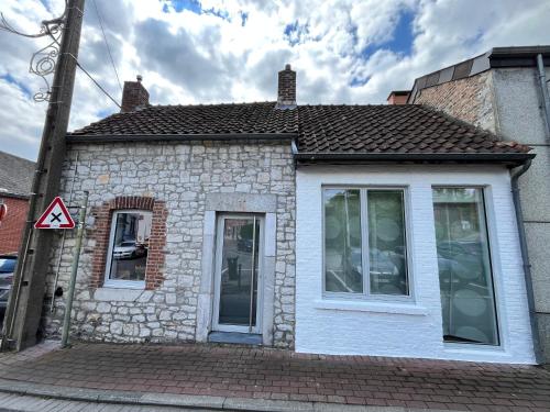 a small brick house with two windows on a street at La maison Mythique in Andenne