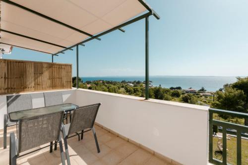 a balcony with a table and a view of the ocean at Pine in the sea Nikiti-Sithonia in Nikiti