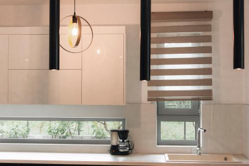 a kitchen with white cabinets and a sink at Zante Luxury Apartment in Argasi