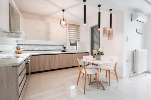 a kitchen with a table and chairs and a refrigerator at Zante Luxury Apartment in Argasi