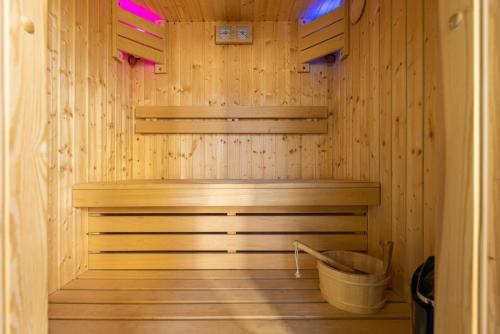 een houten sauna met een bank en een emmer bij Glass House Pirita in Tallinn