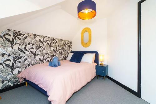 ブリストルにあるEntire 4-bed house - Bristol with Wifi, parking & dedicated workspacesのピンクベッド1台付きのベッドルーム1室、