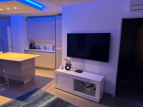 un salon avec une télévision à écran plat sur un mur dans l'établissement Beau 2 pièces en plein centre de Cannes, à Cannes