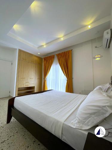 um quarto com uma cama grande e uma janela em Residence P em Kribi
