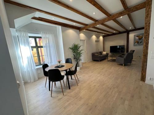 sala de estar con mesa, sillas y sofá en Innerstan nya lägenheter Södramurgatan 45b, en Visby