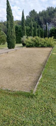 un vaste champ d'herbe planté d'arbres en arrière-plan dans l'établissement Appartement au pied du Luberon, à Mérindol