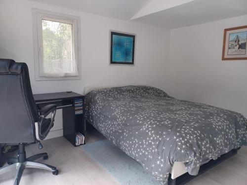 une chambre avec un lit, un bureau et une chaise dans l'établissement Appartement au pied du Luberon, à Mérindol
