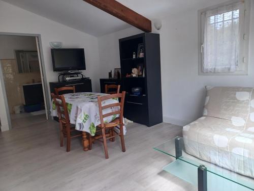un salon avec une table et des chaises et un lit dans l'établissement Appartement au pied du Luberon, à Mérindol