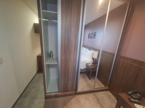 Hóspede já Nobile suites في برازيليا: مرآة كبيرة في غرفة مع سرير