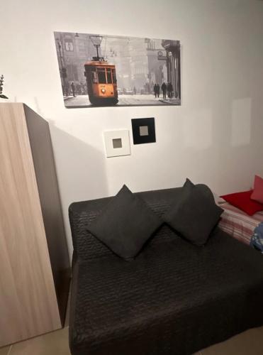 a room with a couch and a picture of a train at Mambo House in Milan