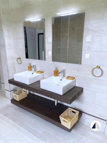uma casa de banho com 2 lavatórios e um espelho em Residence P em Kribi