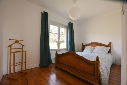 a bedroom with a wooden bed and a window at Le Petit Luquis - maison de campagne 7 chambres - in Chézy-sur-Marne