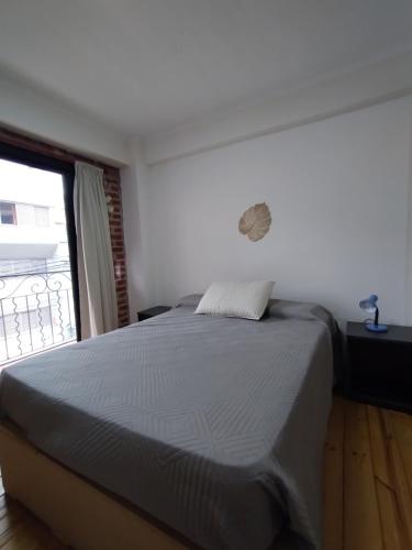 ein großes Bett in einem Zimmer mit Fenster in der Unterkunft Departamento Pleno Centro in San Salvador de Jujuy