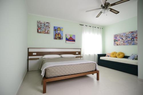 een slaapkamer met twee bedden en een plafondventilator bij MALUSI B&B in Napels