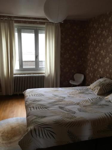 Un dormitorio con una cama blanca con una ventana. en Agréable maison, en Pons