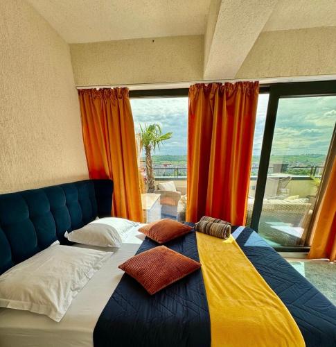 a bed with pillows on it in a room with a window at PENTHOUSE EXCLUSIVE VIEW , Iasi in Iaşi
