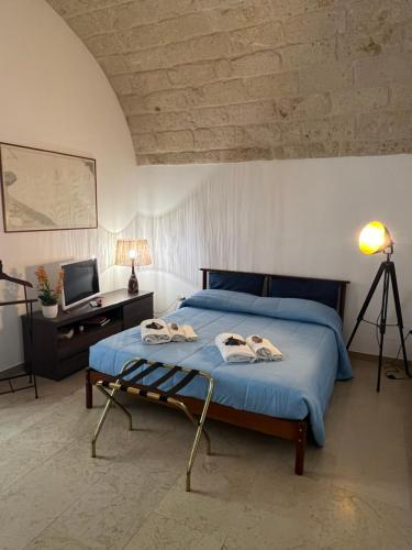 um quarto com uma cama com lençóis azuis e uma secretária em Alle volte… em Bisceglie