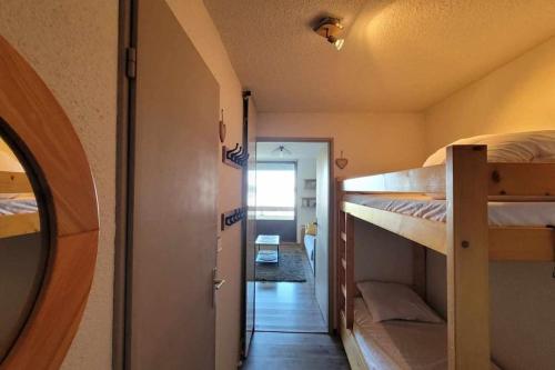 Cette chambre comprend 2 lits superposés et un couloir. dans l'établissement Appartement 4 personnes au pied des pistes, à Saint-François-Longchamp