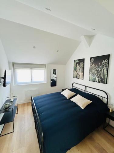 - une chambre avec un grand lit bleu et un bureau dans l'établissement La petite maison, à Loeuilly