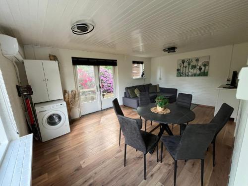 cocina y sala de estar con mesa y sillas en Boshuis Luyksgestel 2-6 personen, veel privacy!, en Luyksgestel